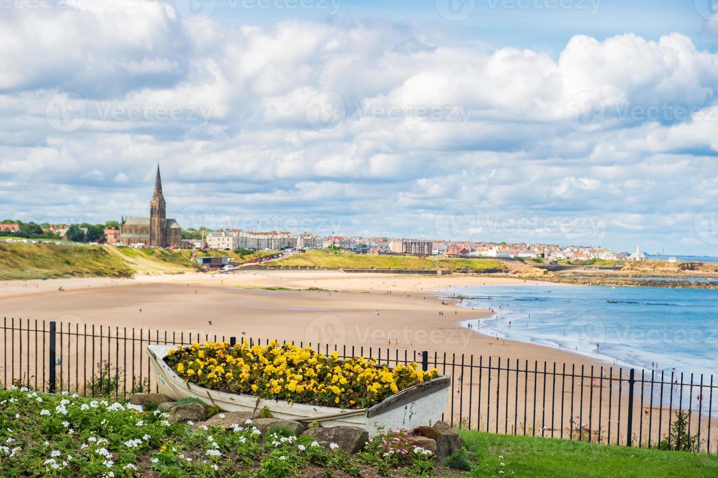 barca ornamentale contenente fiori, con la costa di tynemouth sullo sfondo foto