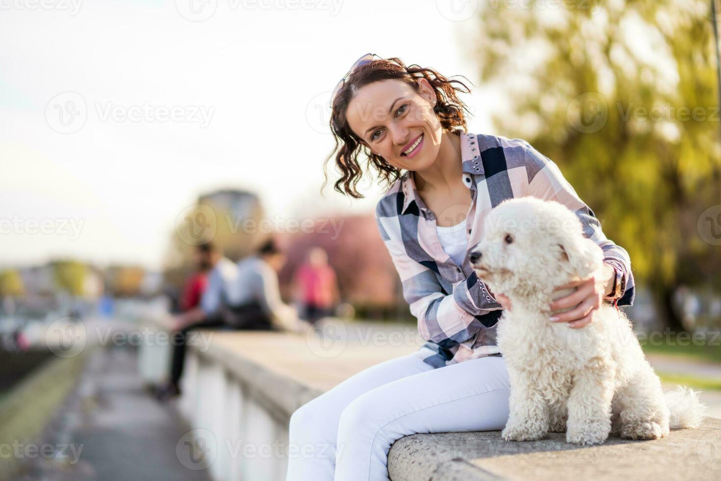 un adulto donna è godendo un' soleggiato giorno con sua cane foto