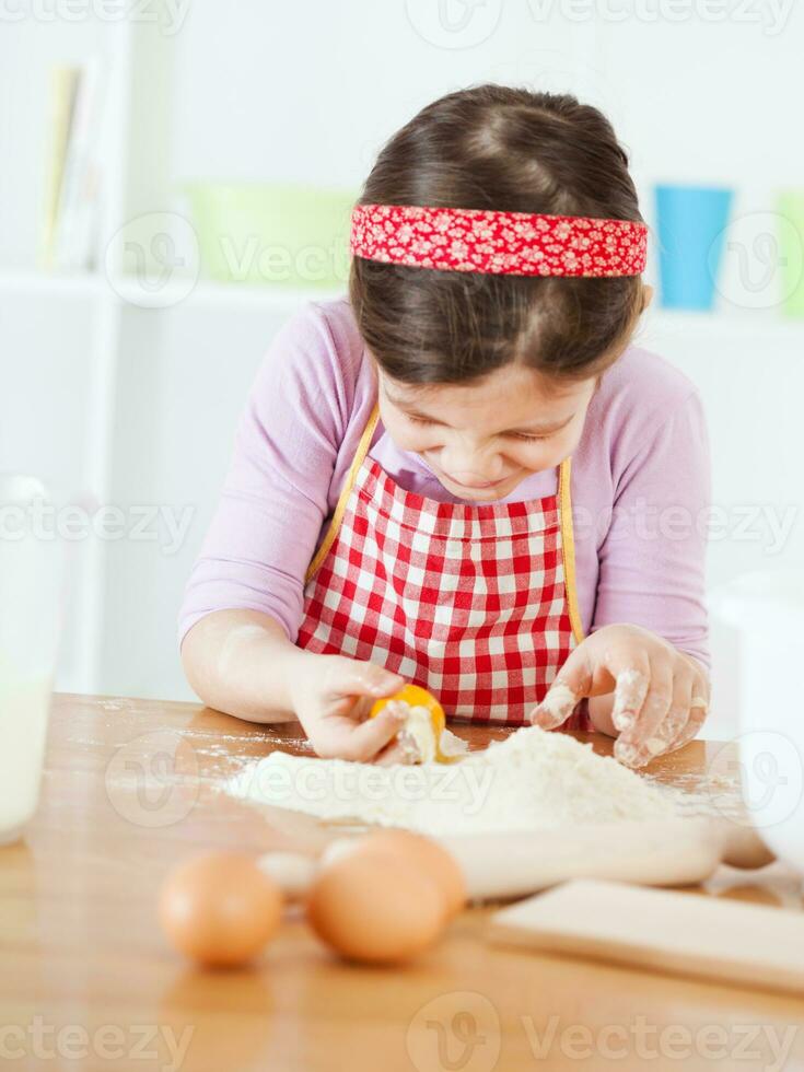 un' giovane ragazza cucinando foto