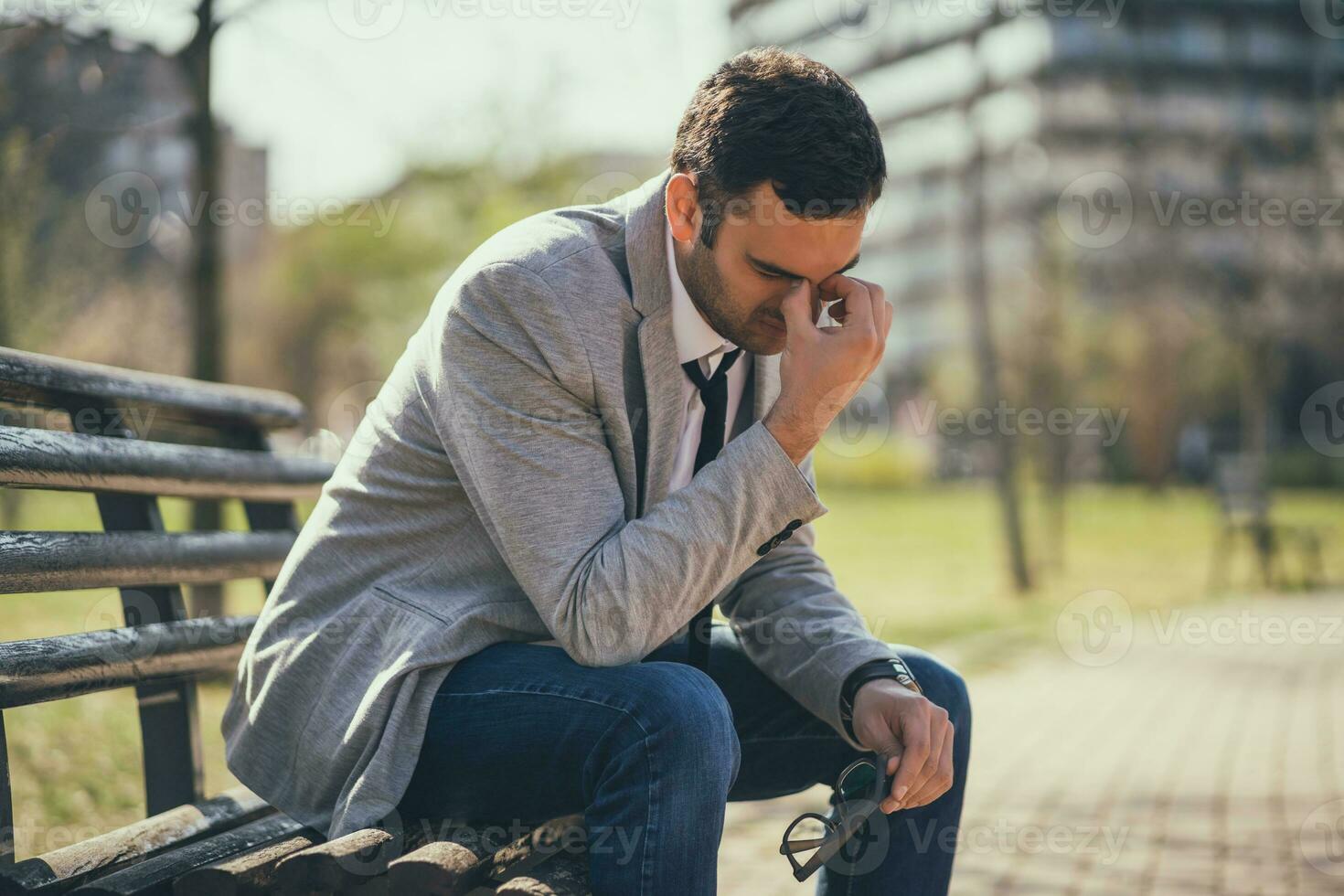 un' uomo d'affari seduta su un' parco panchina foto