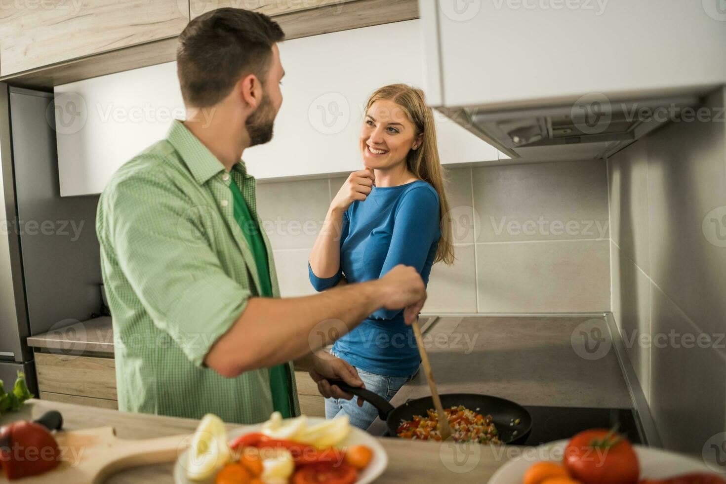 un' giovane coppia cucinando insieme foto