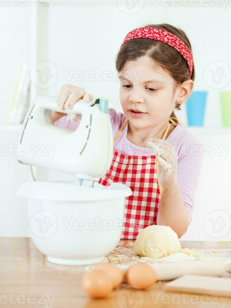 un' giovane ragazza cucinando foto