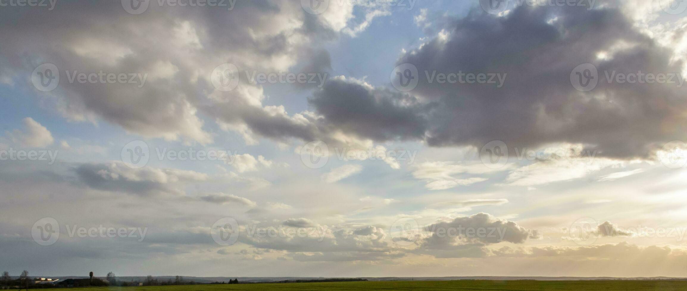 panorama di tempesta nuvole al di sopra di il campo. bellissimo paesaggio a tramonto. nuvoloso cielo bandiera foto