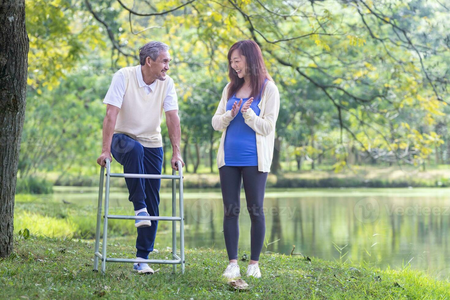 asiatico anziano uomo con camminatore e il suo figlia a piedi insieme nel il parco fare leggero esercizio e fisico terapia per muscolo edificio nel longevità e salutare stile di vita dopo la pensione concetto. foto