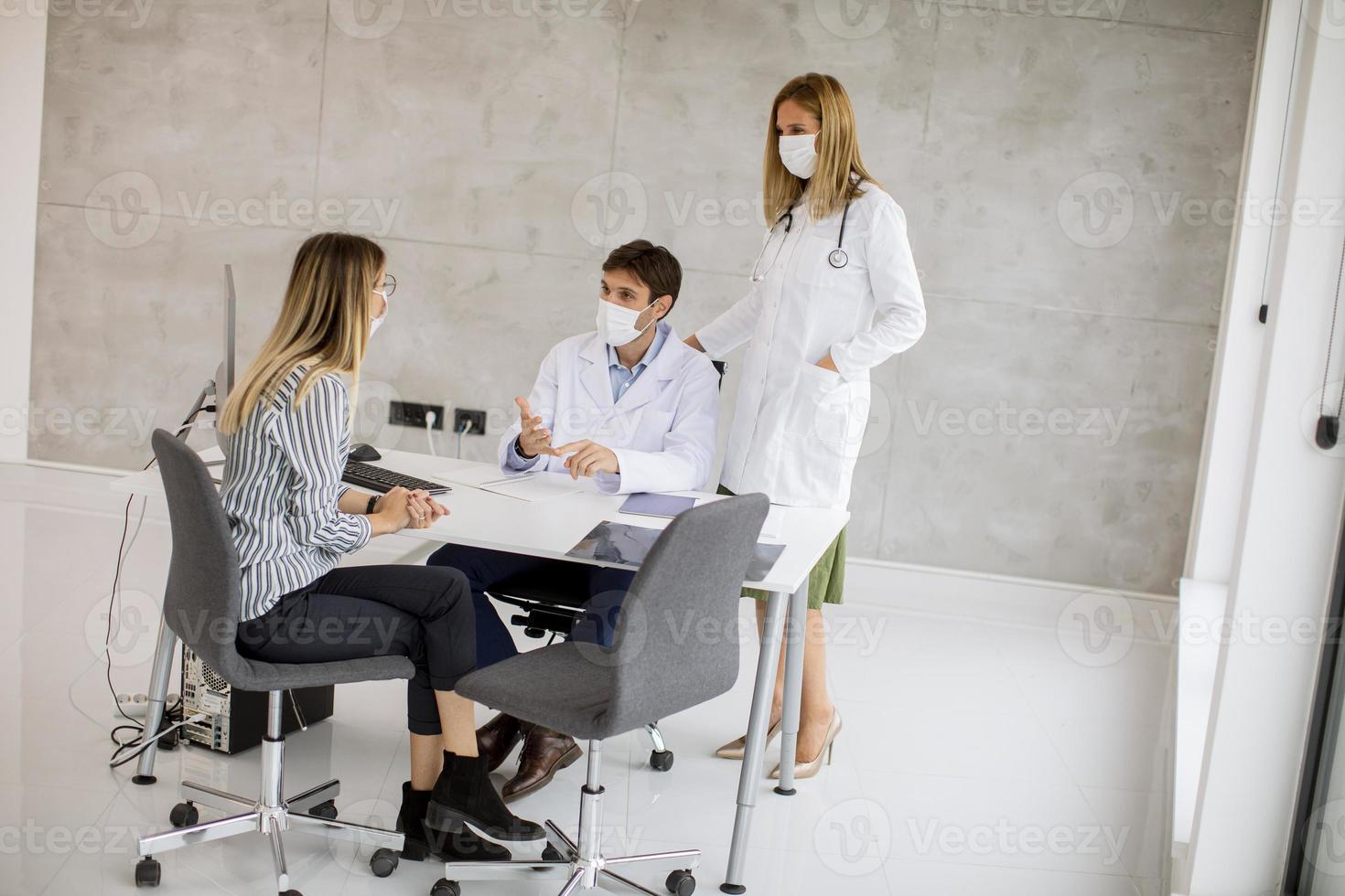 medici che parlano con il paziente con le maschere foto