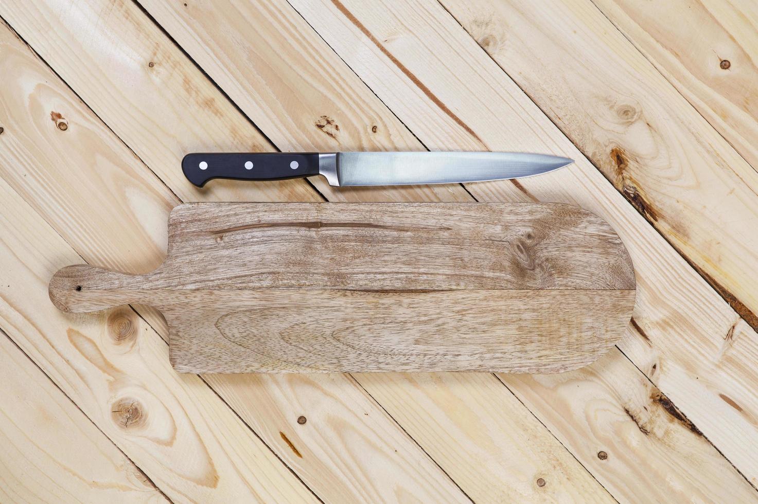 tagliere con coltello sul tavolo di legno foto