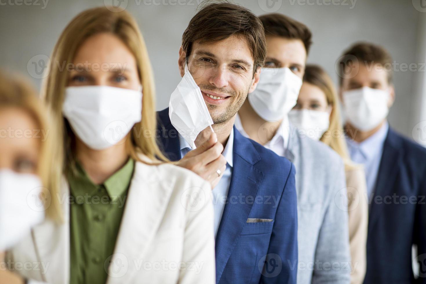 primo piano di professionisti che indossano maschere con uomo che toglie la maschera foto