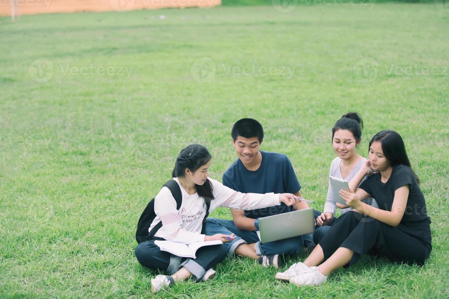 gruppo di studenti seduti in erba foto