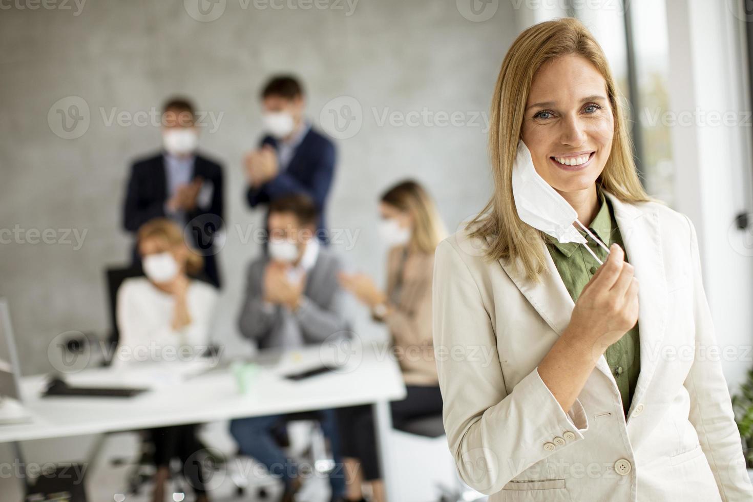 donna di affari che toglie la maschera foto