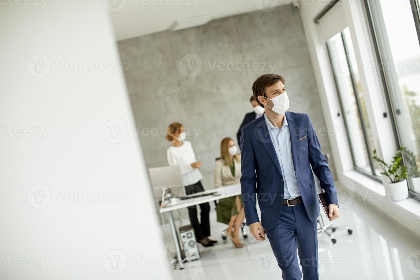 uomo che indossa una maschera e si allontana da una riunione foto