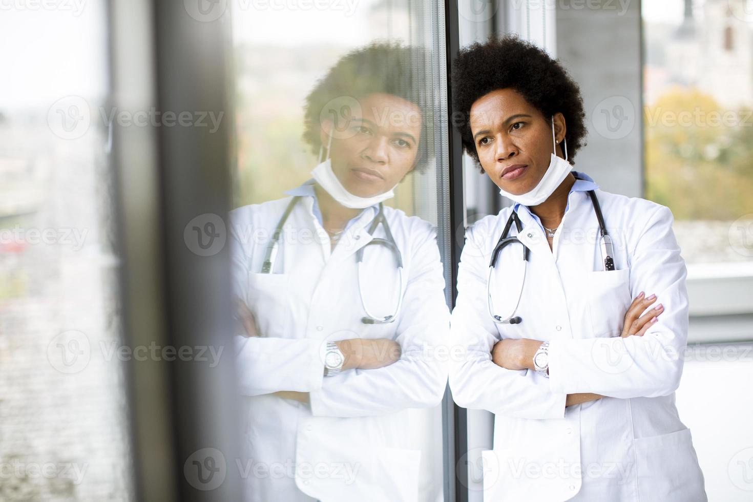 stanco medico a guardare fuori dalla finestra foto