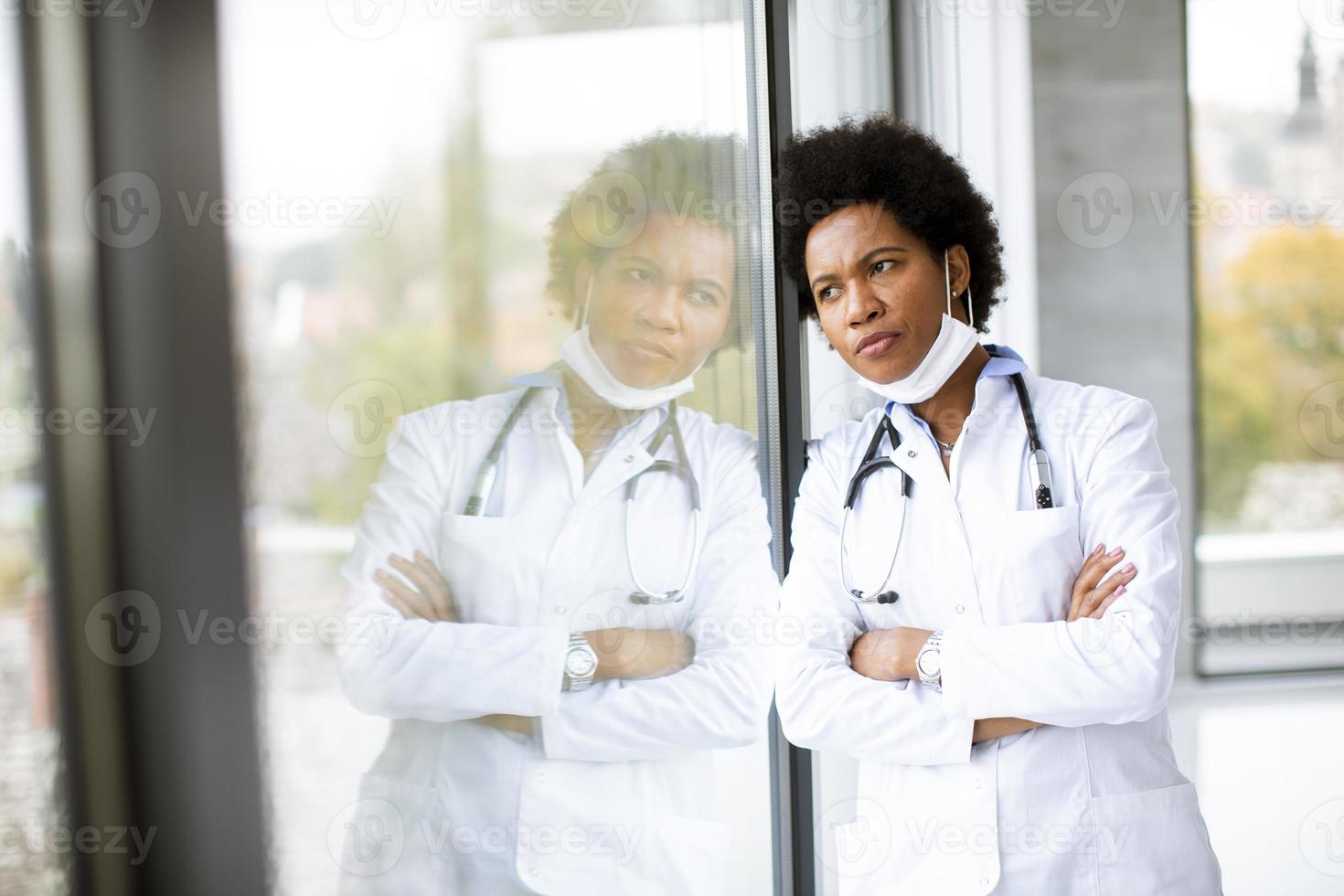 medico che pensa mentre guarda fuori dalla finestra foto