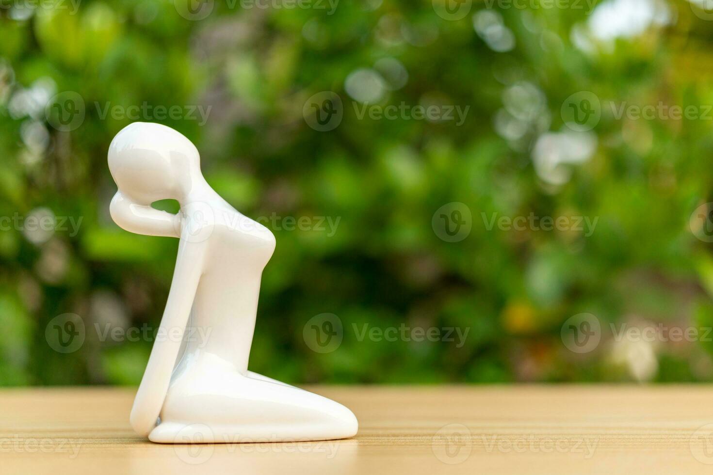 ceramica yoga figurina di donna fare yoga posa su di legno pavimento e verde foglia sfondo foto