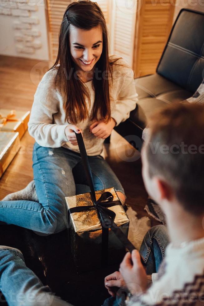 ragazzo e una ragazza festeggiano il nuovo anno insieme e si scambiano regali foto