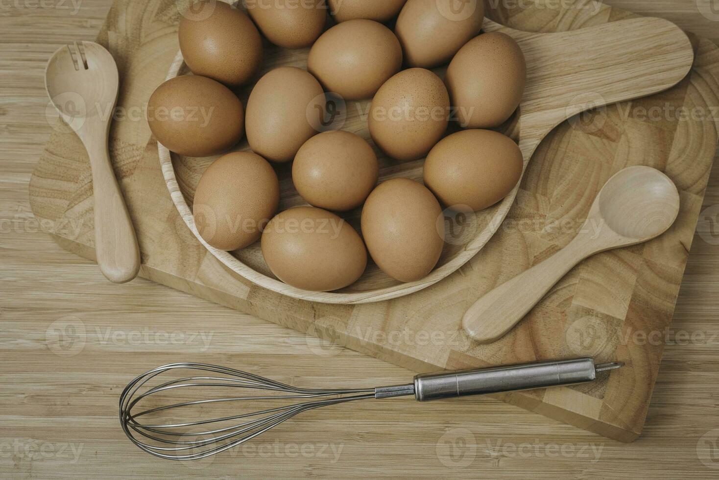 cucina metallo filo e crudo uova su il di legno tavola foto