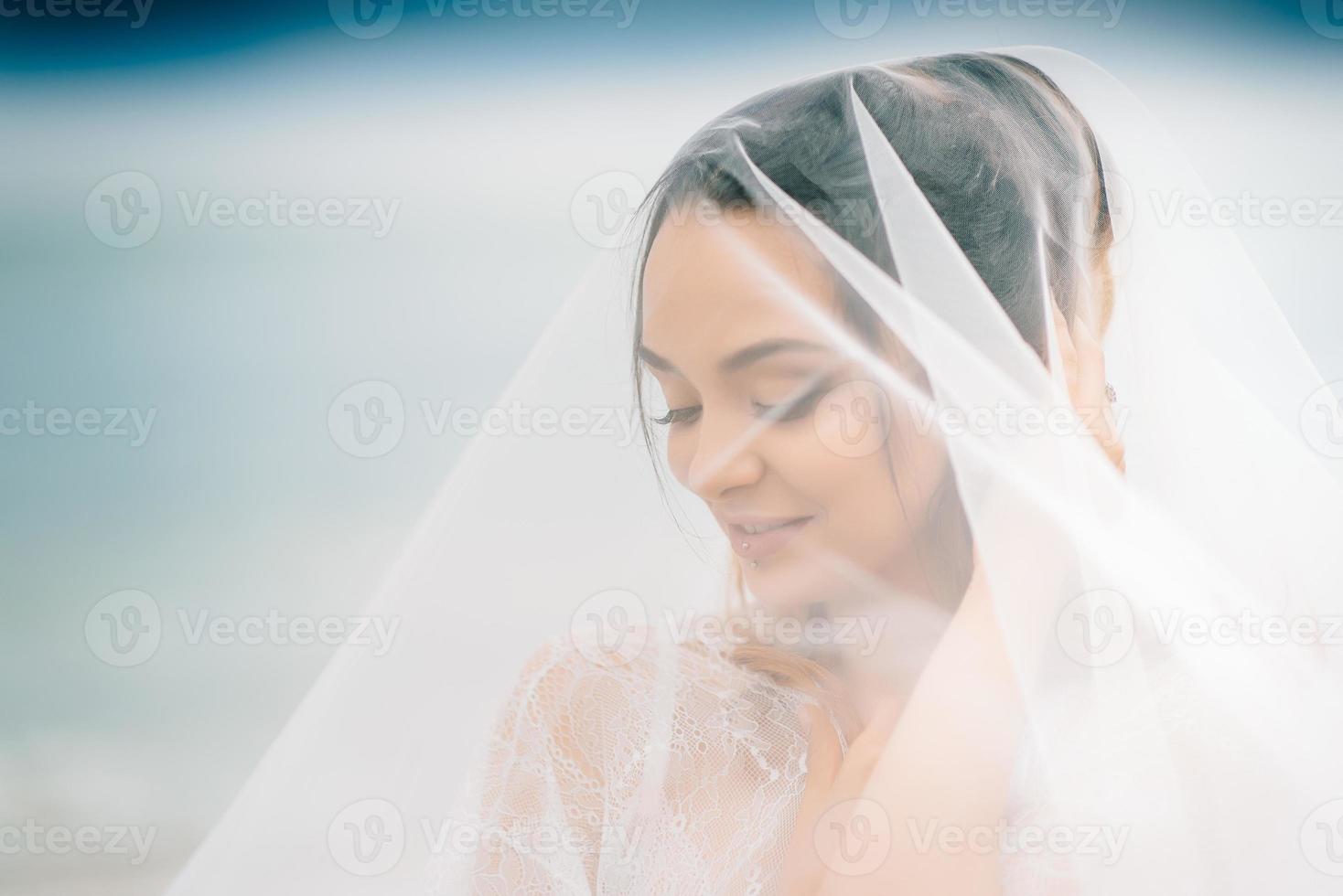 primo piano della sposa sotto un velo foto