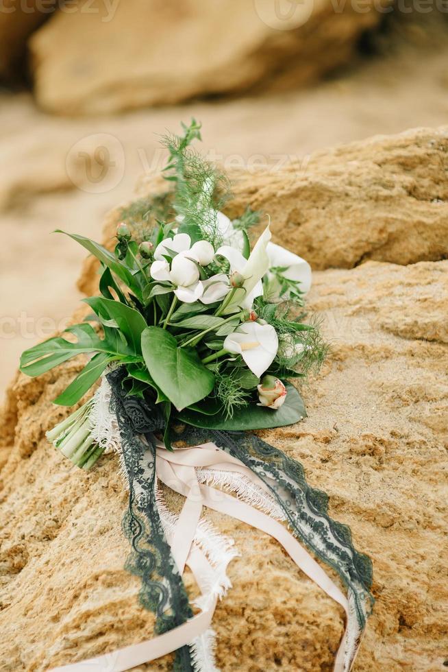 bouquet di una sposa di rose si trova su un'arenaria foto