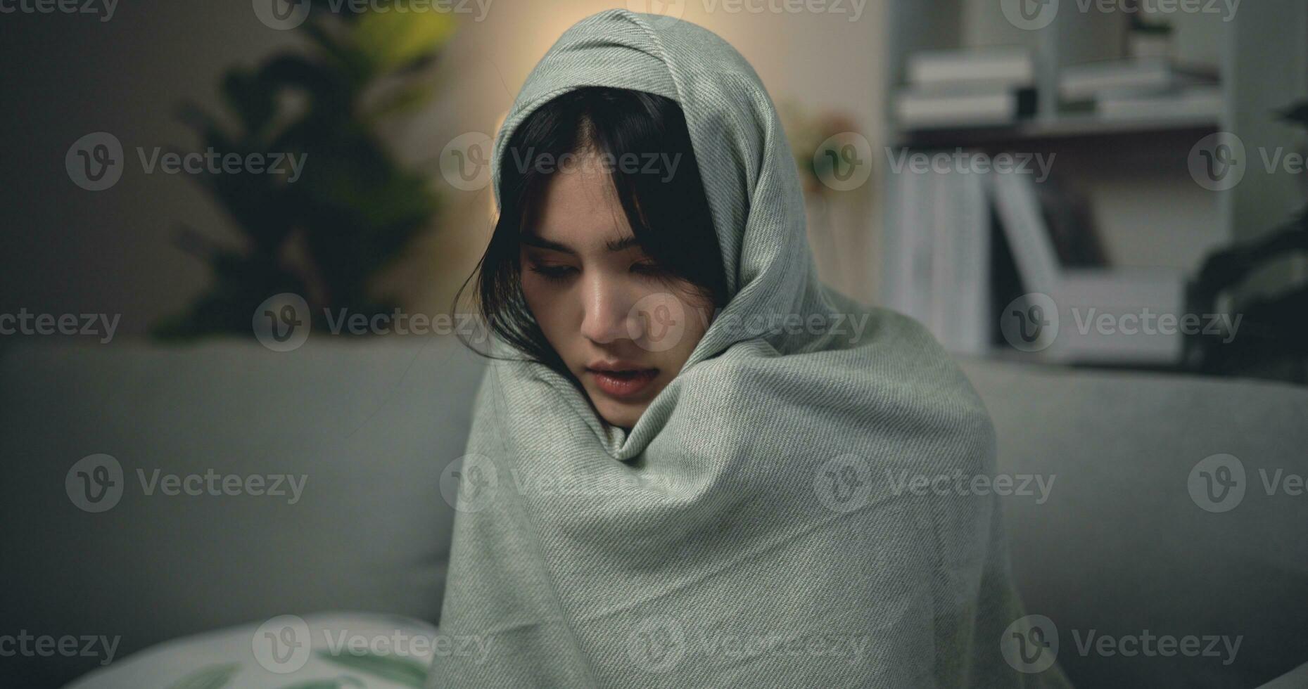 asiatico giovane donna seduta sotto coperta con sofferenza a partire dal freddo e influenza a casa foto