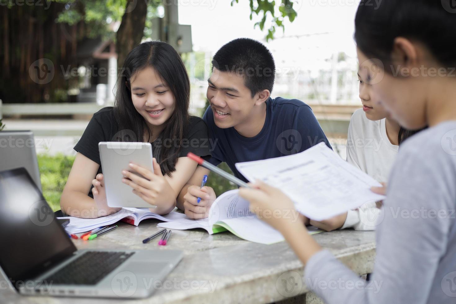 studenti asiatici che utilizzano tablet e notebook nel campus foto