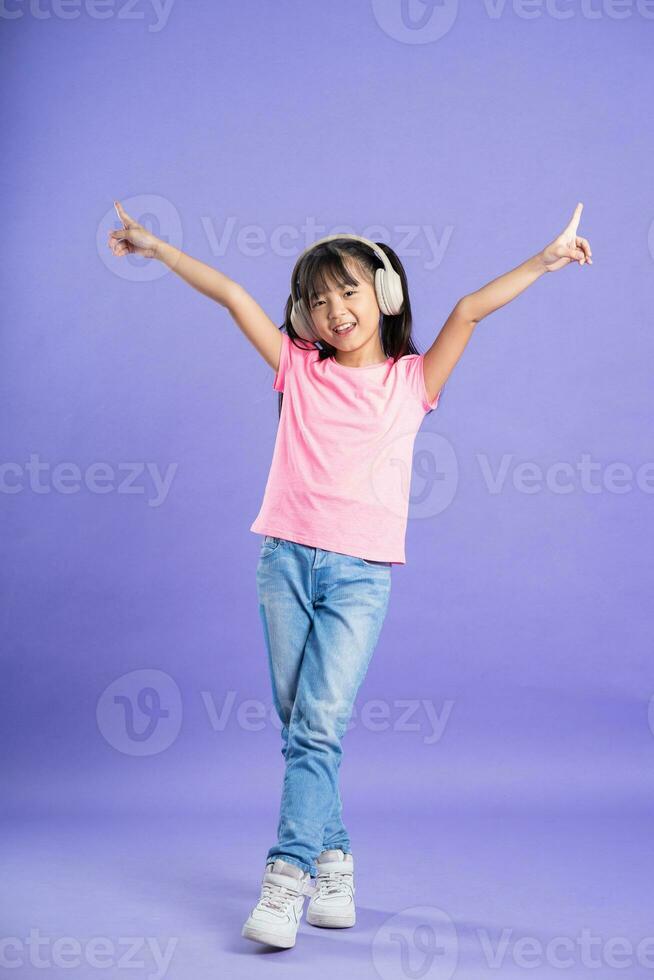 carino asiatico bambino ragazza in posa su viola sfondo foto