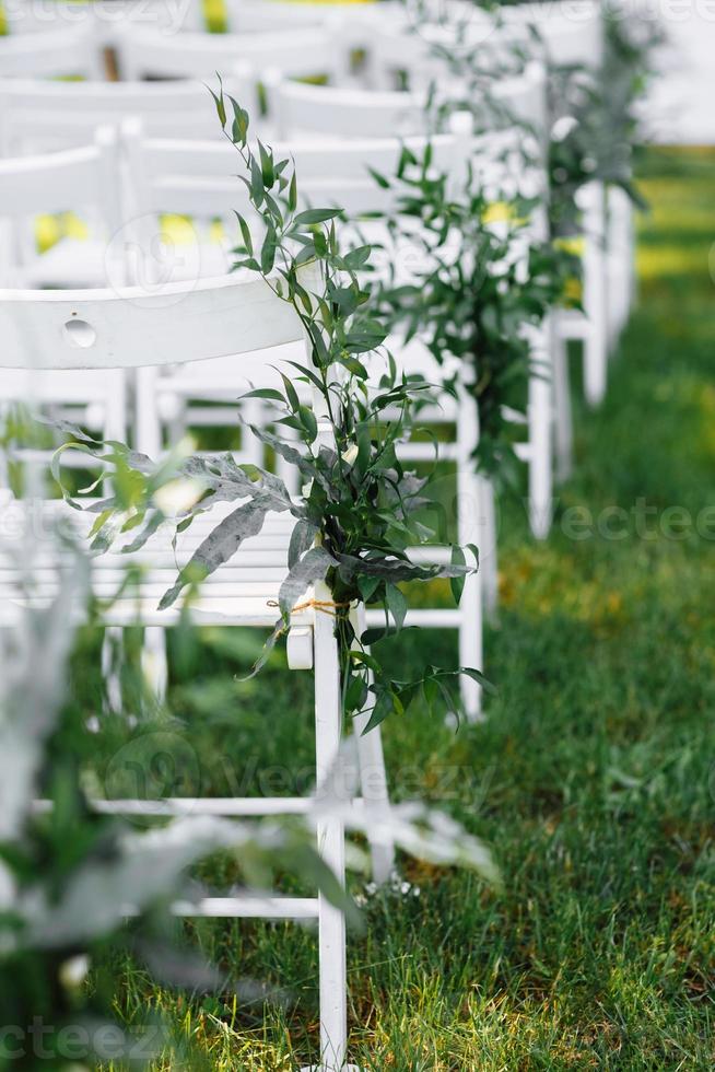 sedie bianche decorate a una cerimonia di matrimonio foto