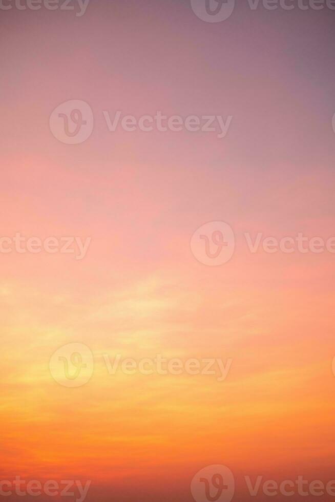 bellissimo , lusso morbido pendenza arancia oro nuvole e luce del sole su il blu cielo Perfetto per il sfondo, prendere nel eternità, crepuscolo, verticale Immagine foto