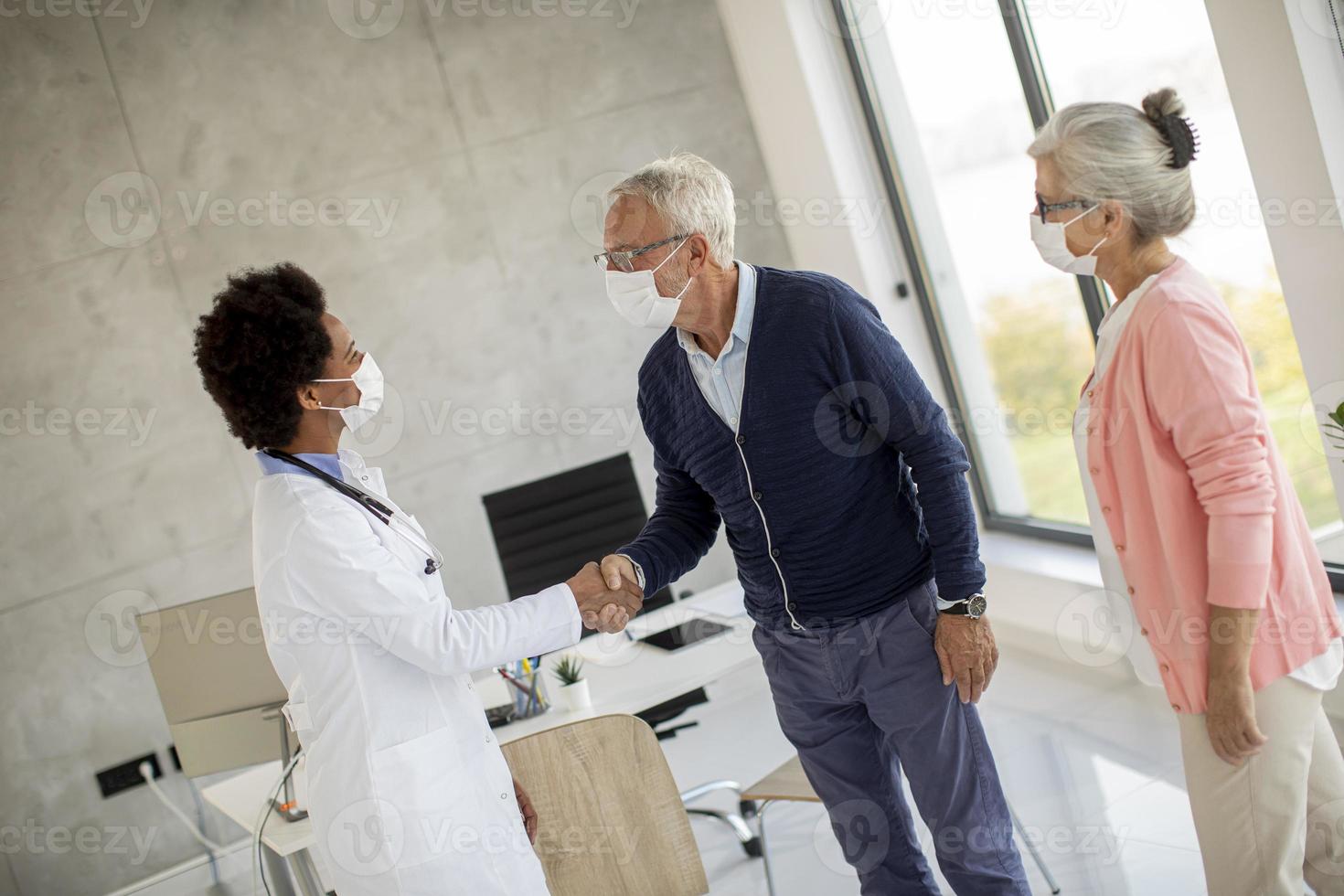 coppia matura saluto medico con maschere foto