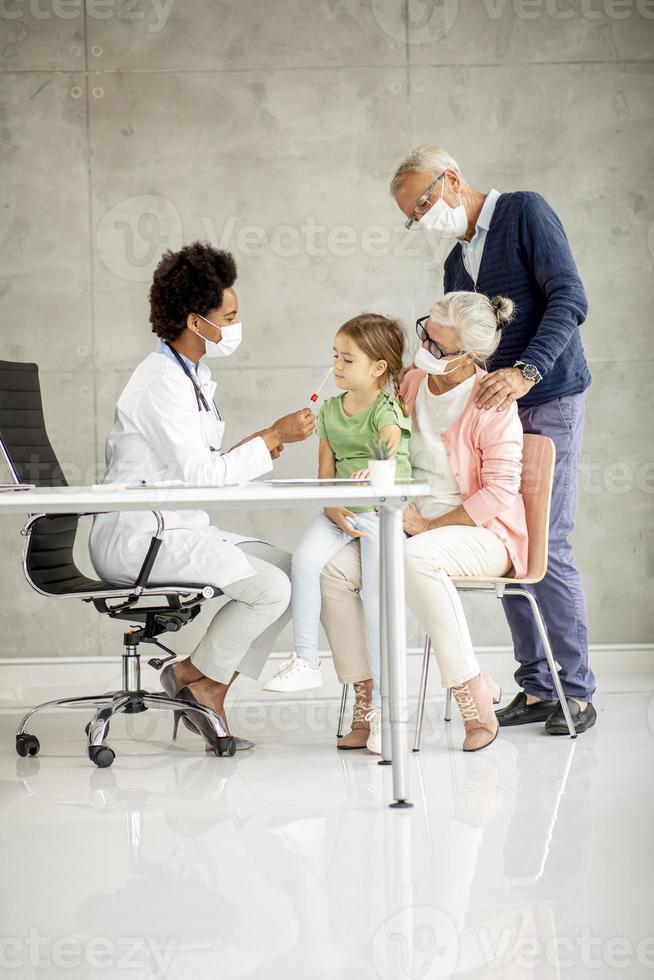 vista verticale di nonni e nipote presso l'ufficio del medico foto