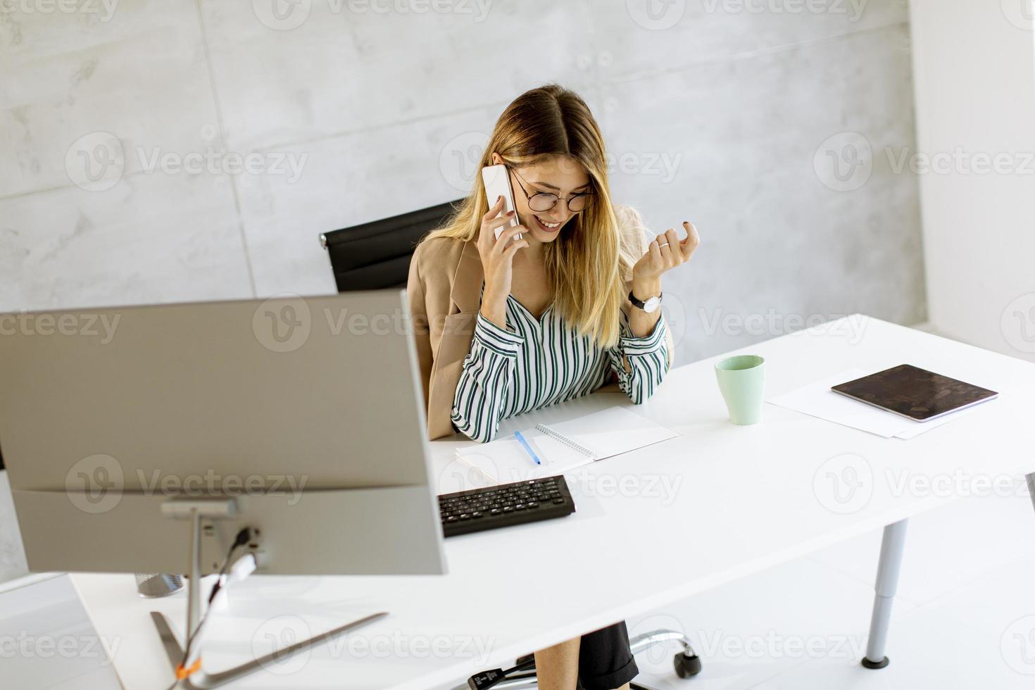 imprenditrice sul telefono in ufficio moderno foto