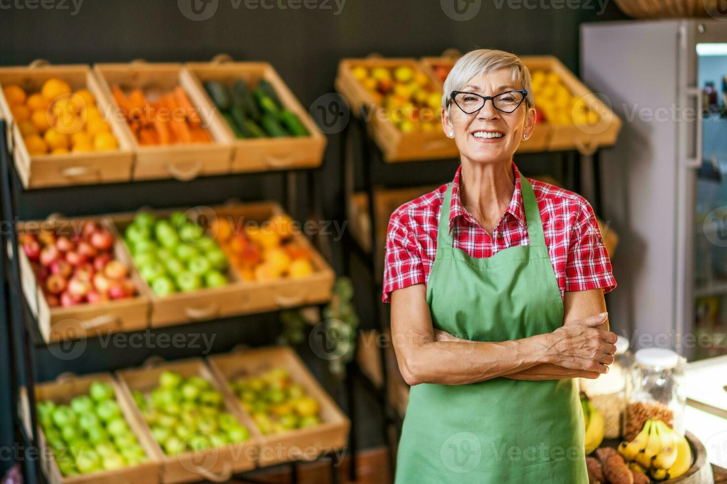 maturo donna lavori nel frutta e verdure negozio. ritratto di piccolo attività commerciale supermercato proprietario. foto