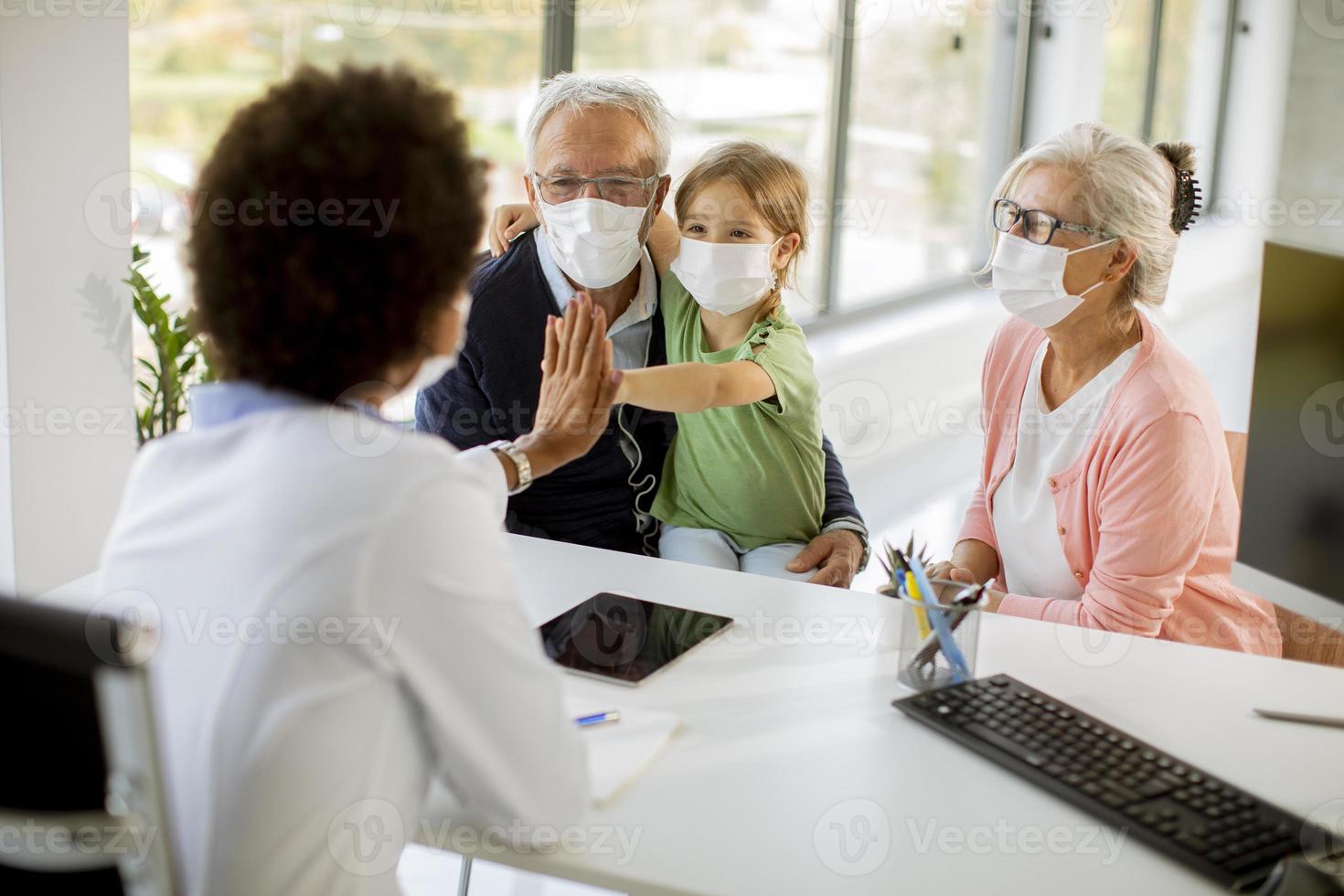 medico che parla con nonni e nipote foto