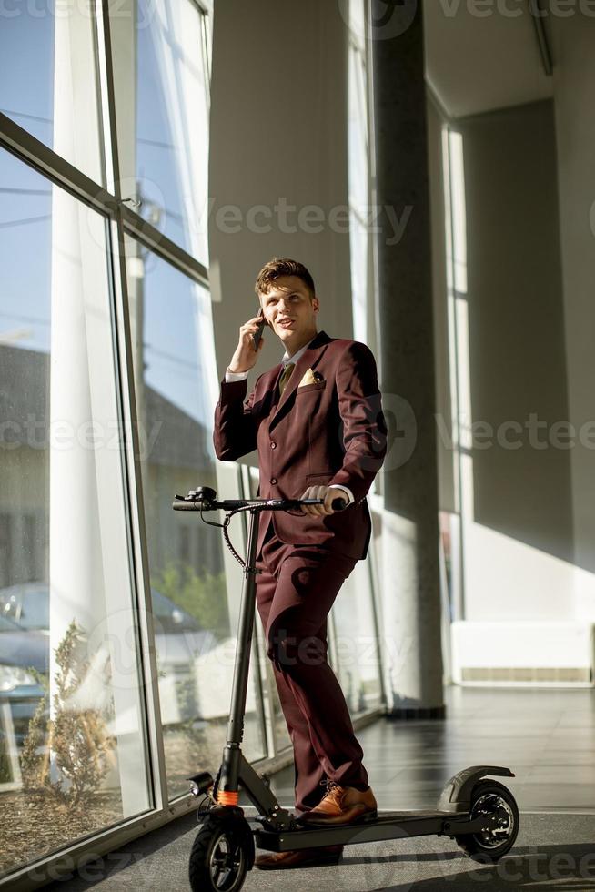 vista verticale di un uomo d'affari su uno scooter e un telefono foto