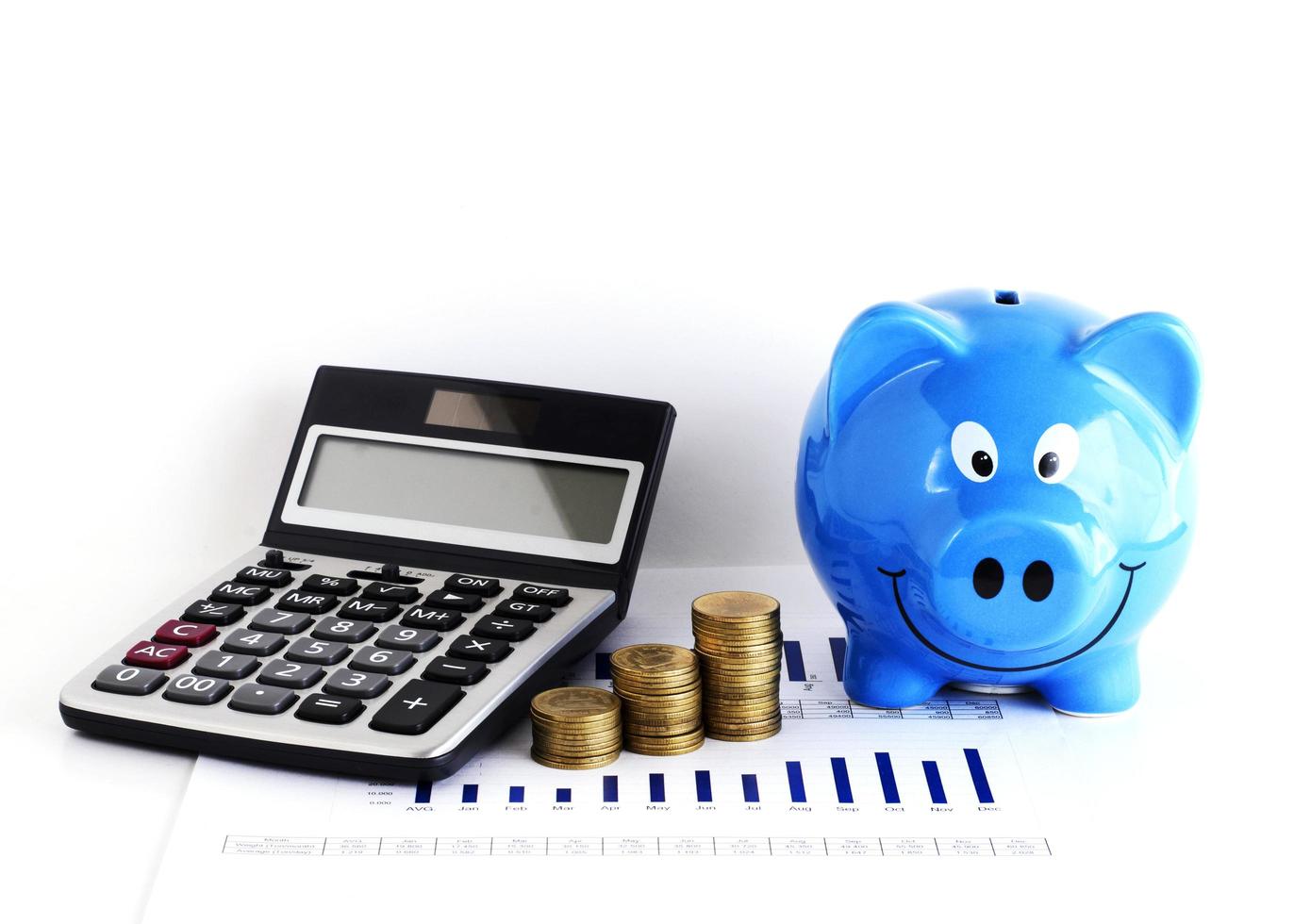 calcolatrice denaro moneta pila e salvadanaio blu per il concetto di prestiti foto