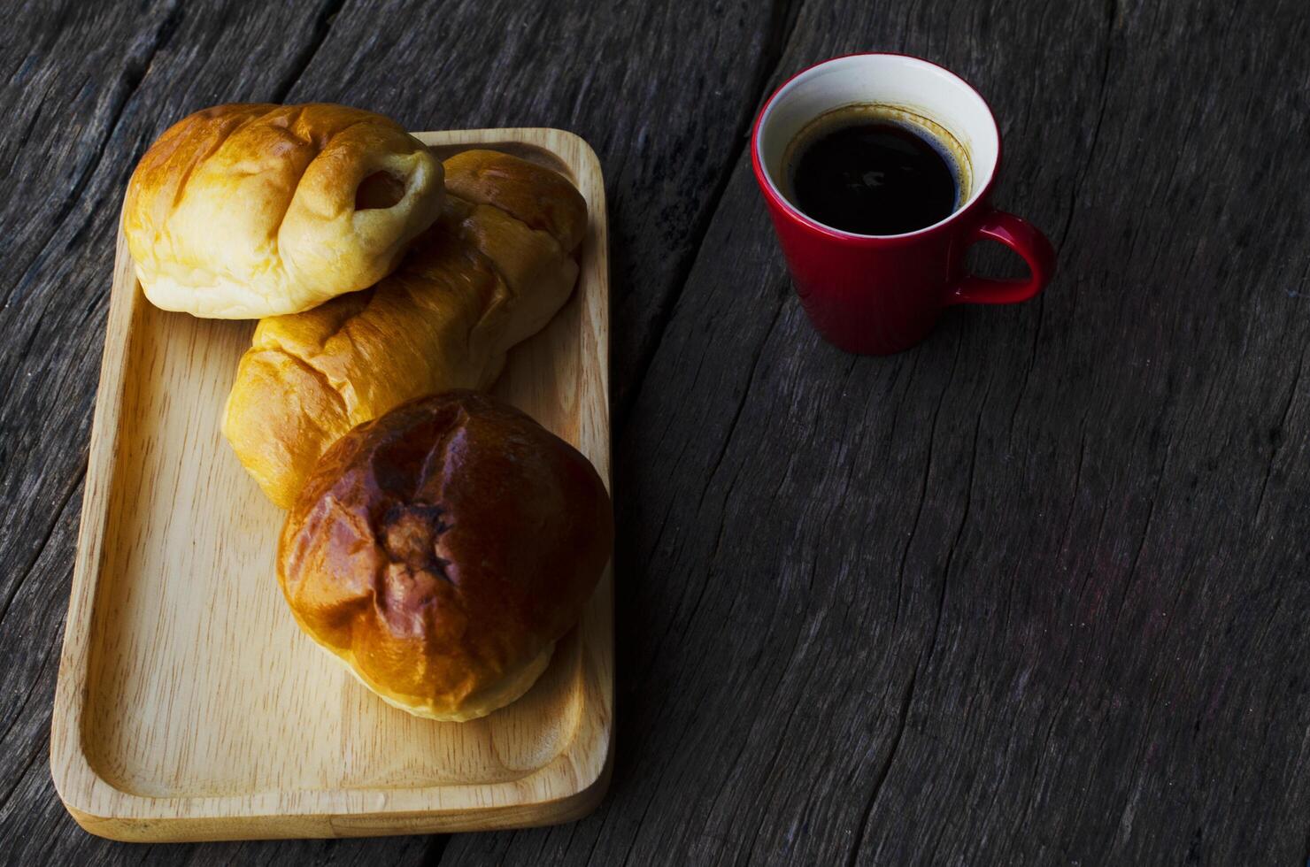 tazza di caffè espresso rosso e gustosi panini sul fondo della tavola in legno foto