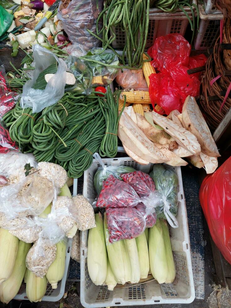 agricoltori' cibo mercato stalla con varietà di biologico verdura. venditore servendo e chiacchierando con clienti. foto