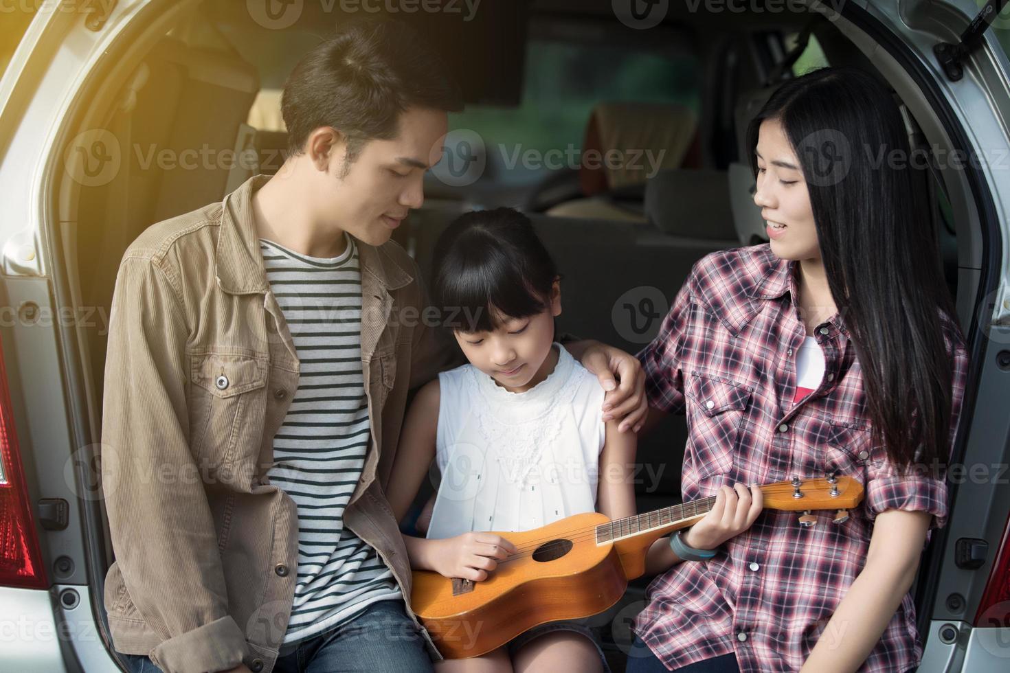 famiglia che suona l'ukulele insieme in campeggio foto