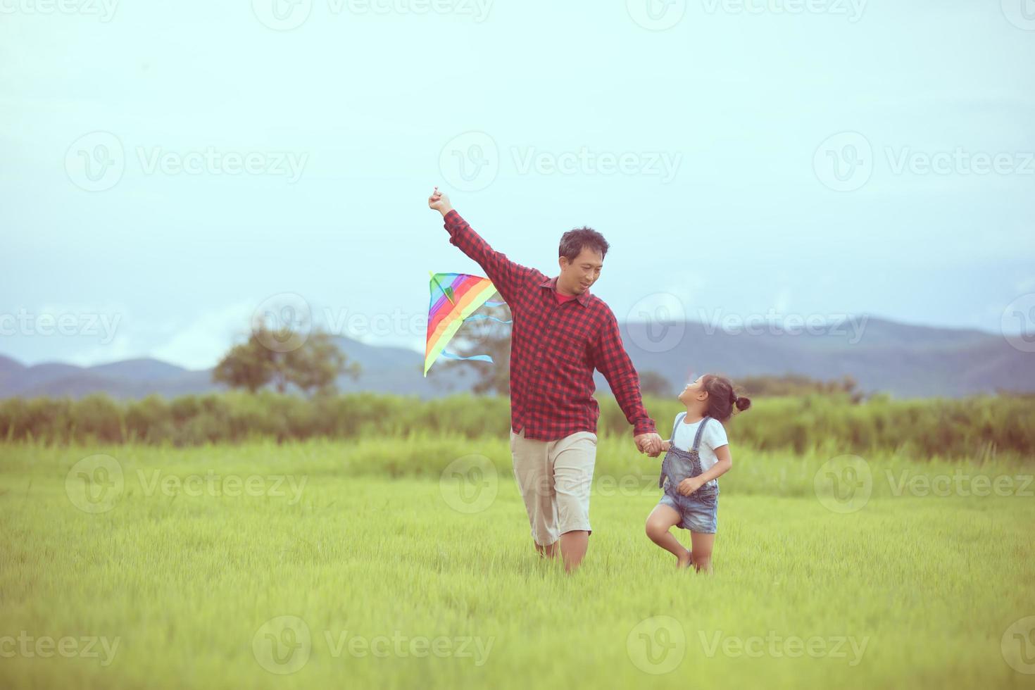 bambino e padre che giocano con l'aquilone nel parco foto