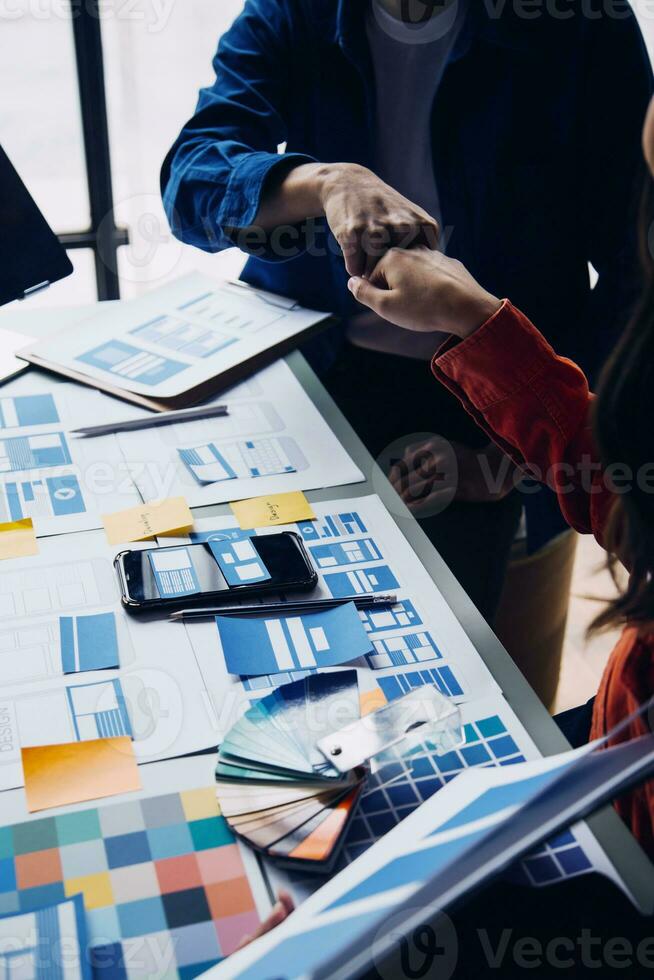 vicino su UX sviluppatore e ui progettista di brainstorming di mobile App interfaccia wireframe design su tavolo con cliente breve e colore codice a moderno ufficio.creativo digitale sviluppo agenzia foto