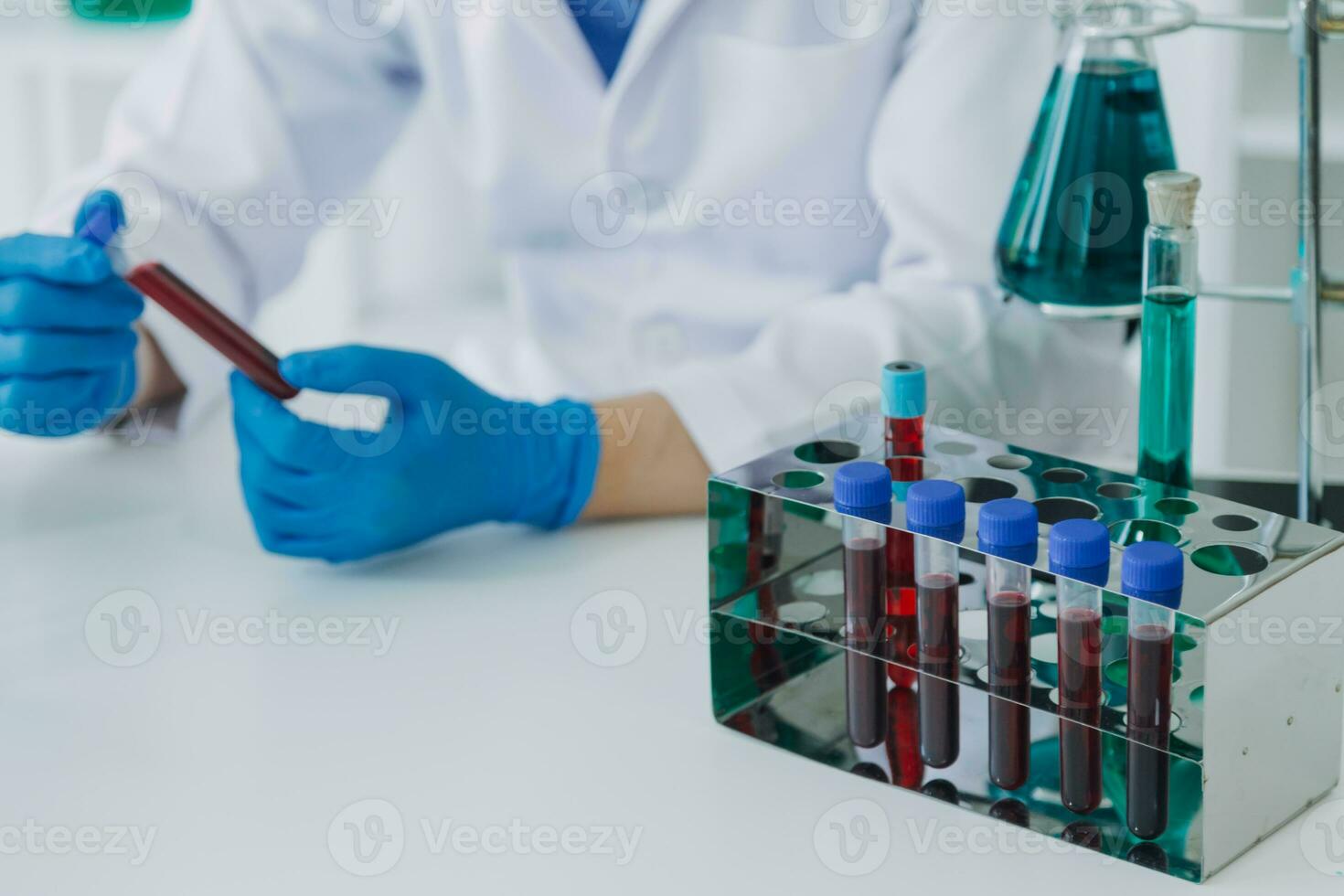 mano di scienziato con test tubo e borraccia nel medico chimica laboratorio blu bandiera sfondo foto