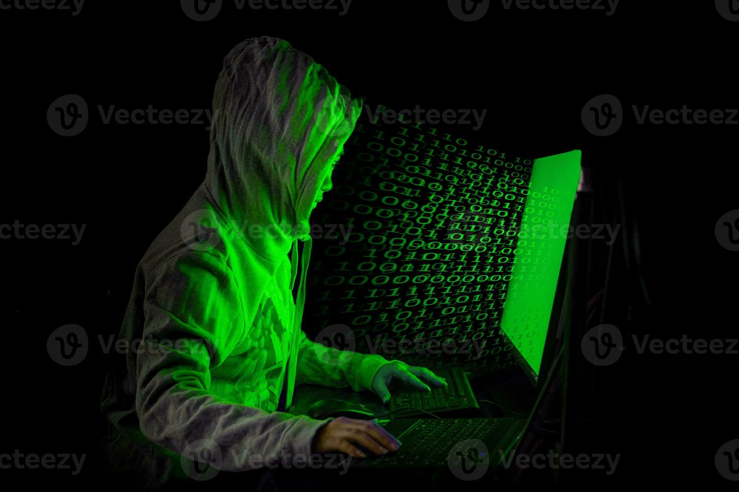 donne hacker irrompe nei server di dati del governo e infetta il loro sistema con un virus nel suo nascondiglio, atmosfera blu scuro, donna incappucciata che utilizza laptop con sfondo di codice binario, concetto di malware foto