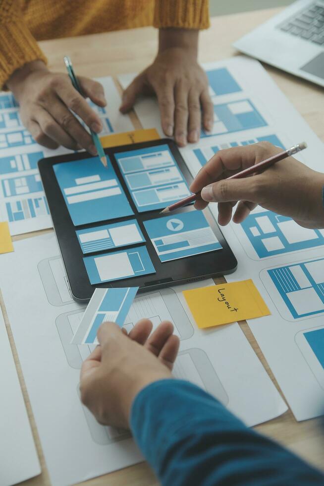 vicino su UX sviluppatore e ui progettista di brainstorming di mobile App interfaccia wireframe design su tavolo con cliente breve e colore codice a moderno ufficio.creativo digitale sviluppo agenzia foto