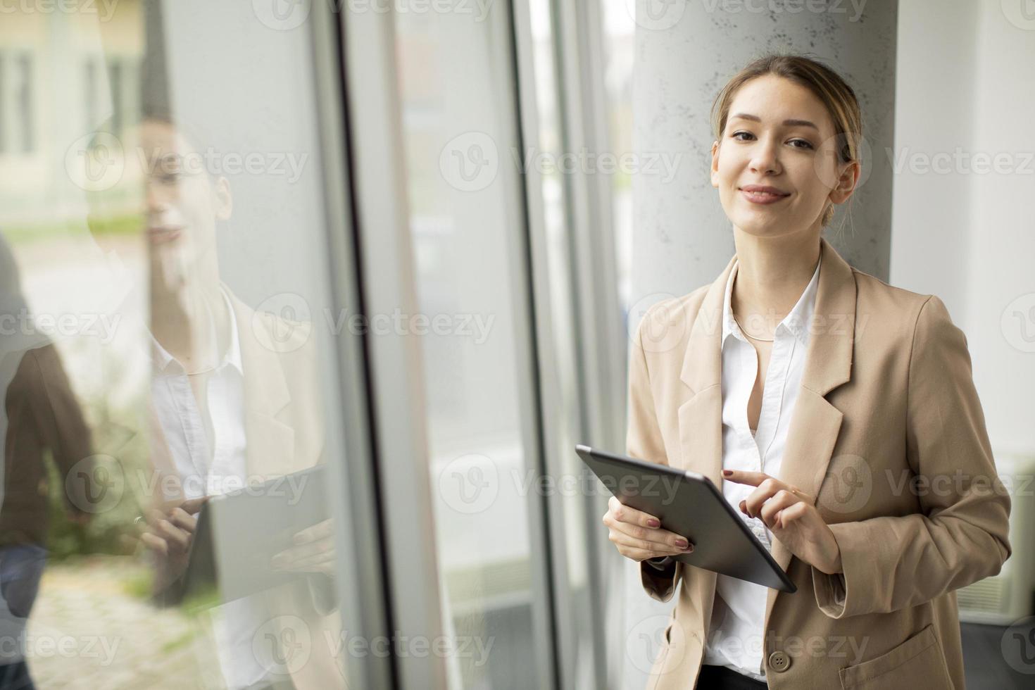 donna che tiene un tablet e guardando la telecamera foto