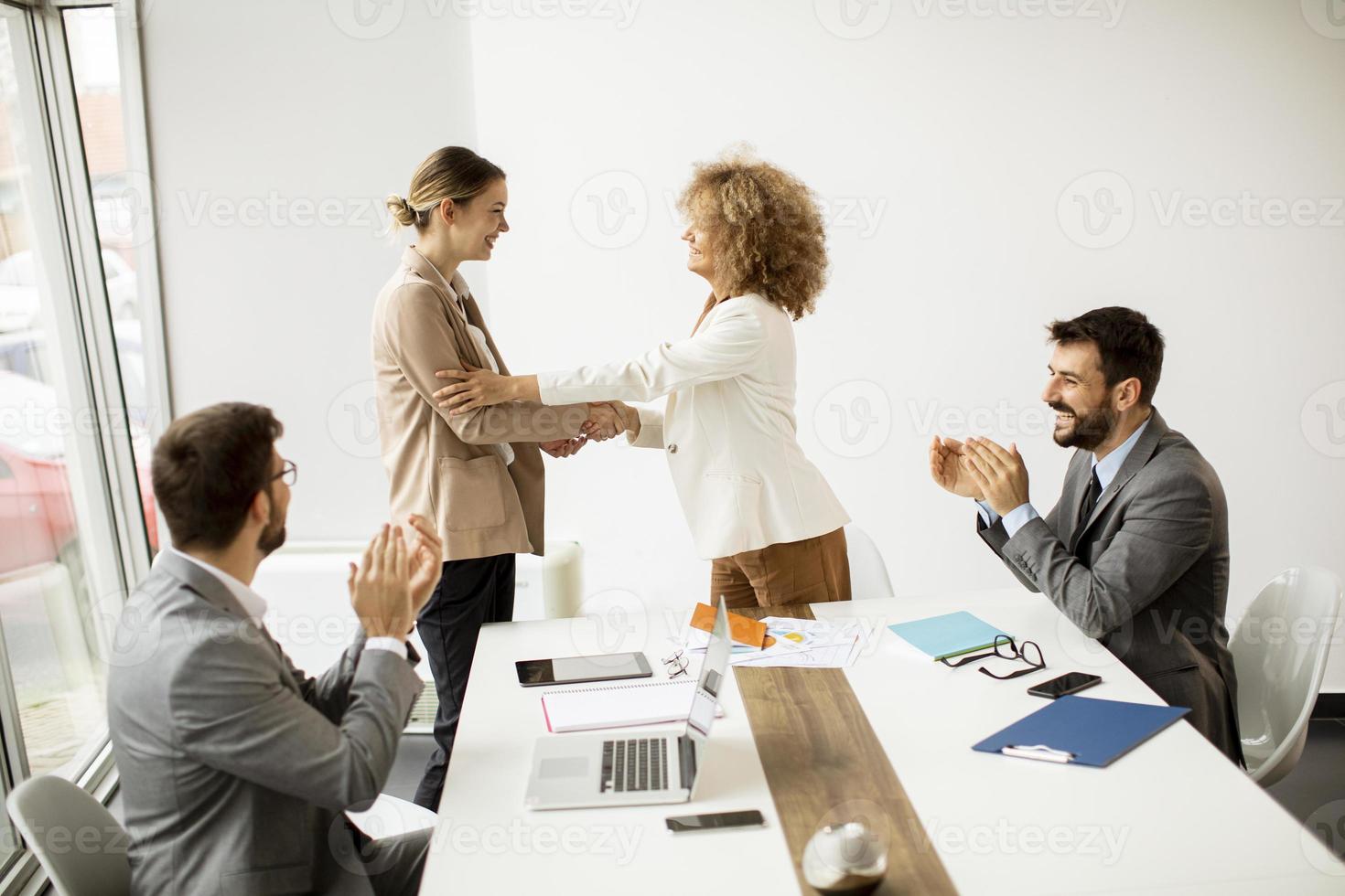 donne si stringono la mano in una riunione foto