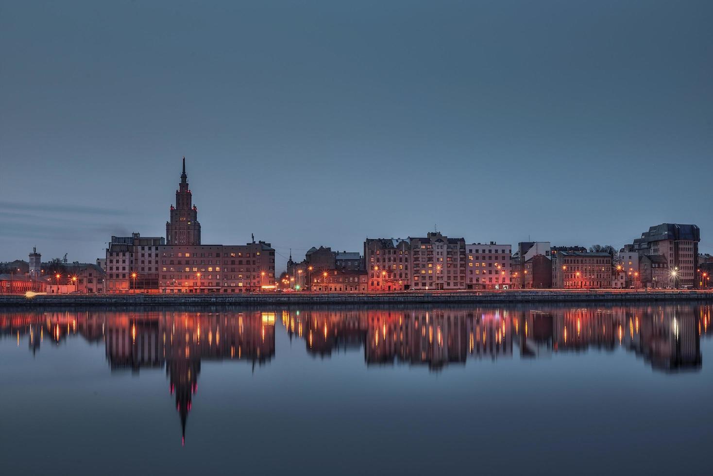 vista notturna sulla riva del fiume illuminata con la riflessione sul fiume a riga foto