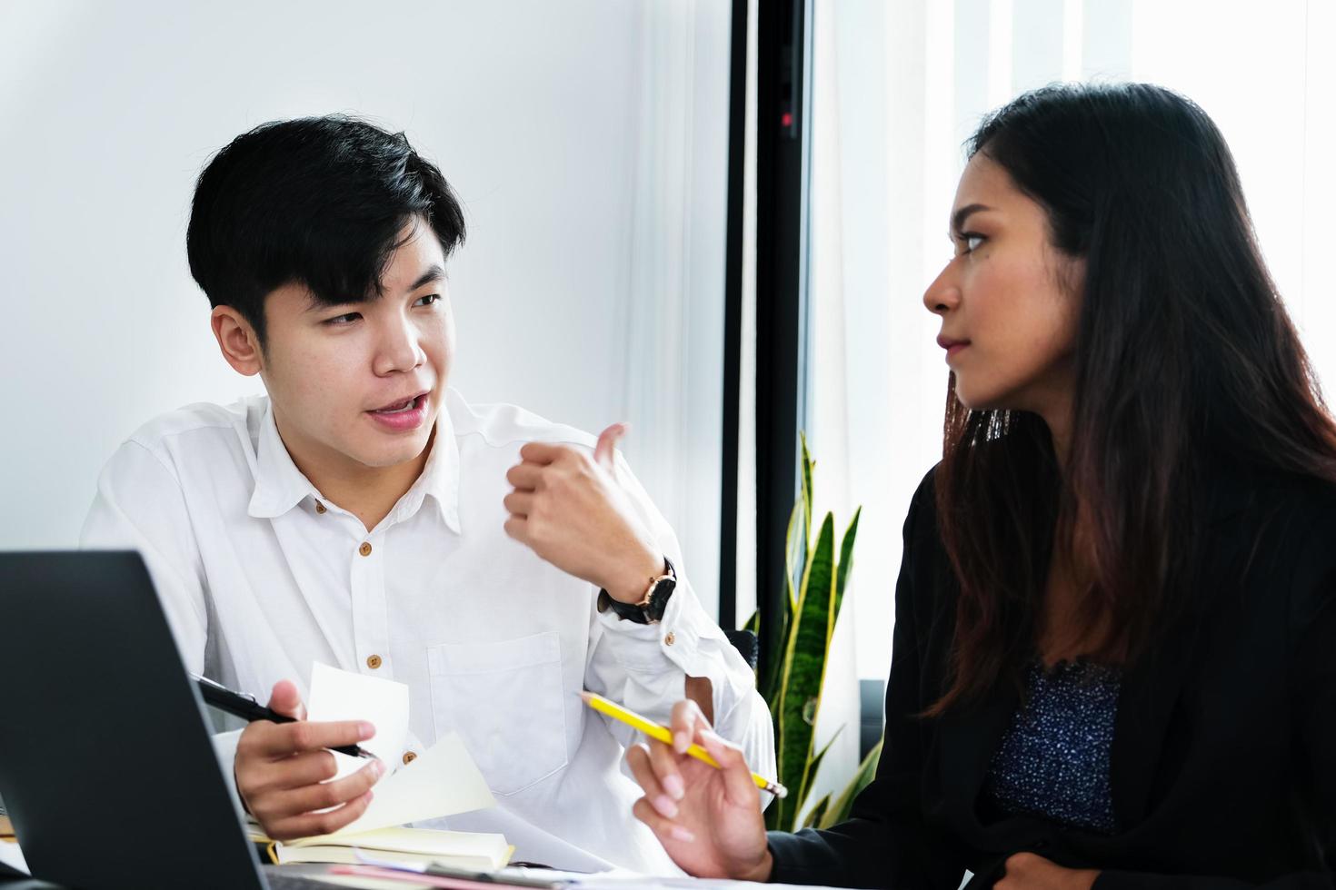 due giovani dirigenti aziendali stanno discutendo di cambiare il loro concetto di business per aumentare i profitti e la forza della loro attività. foto