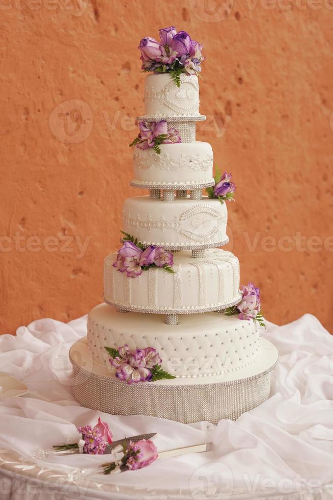 torta nuziale bianca decorata con fiori foto