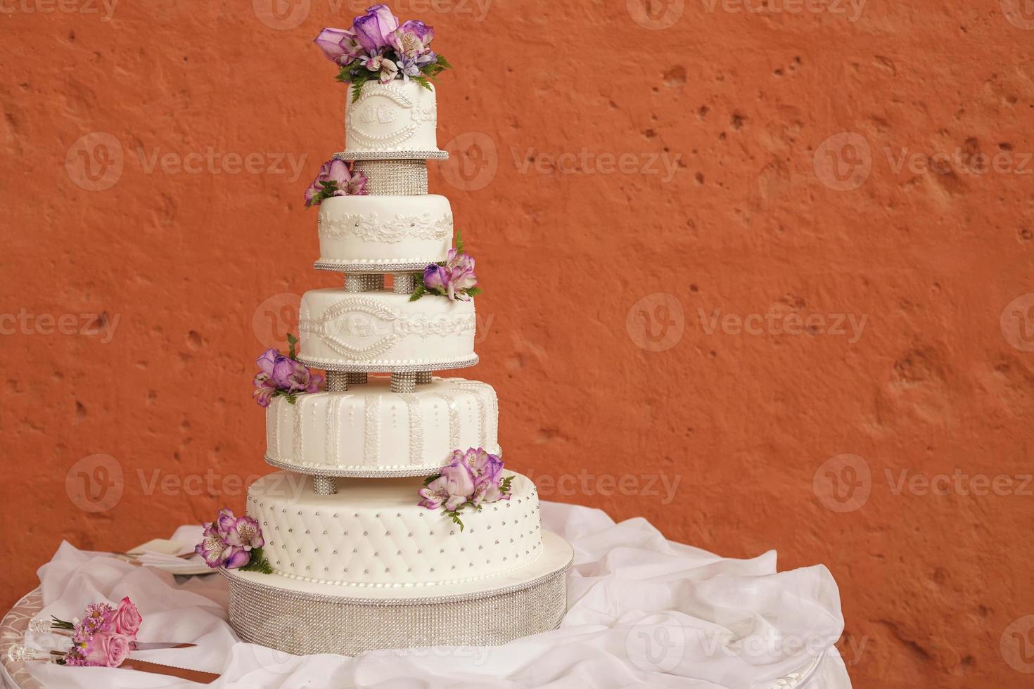 torta nuziale bianca decorata con fiori foto