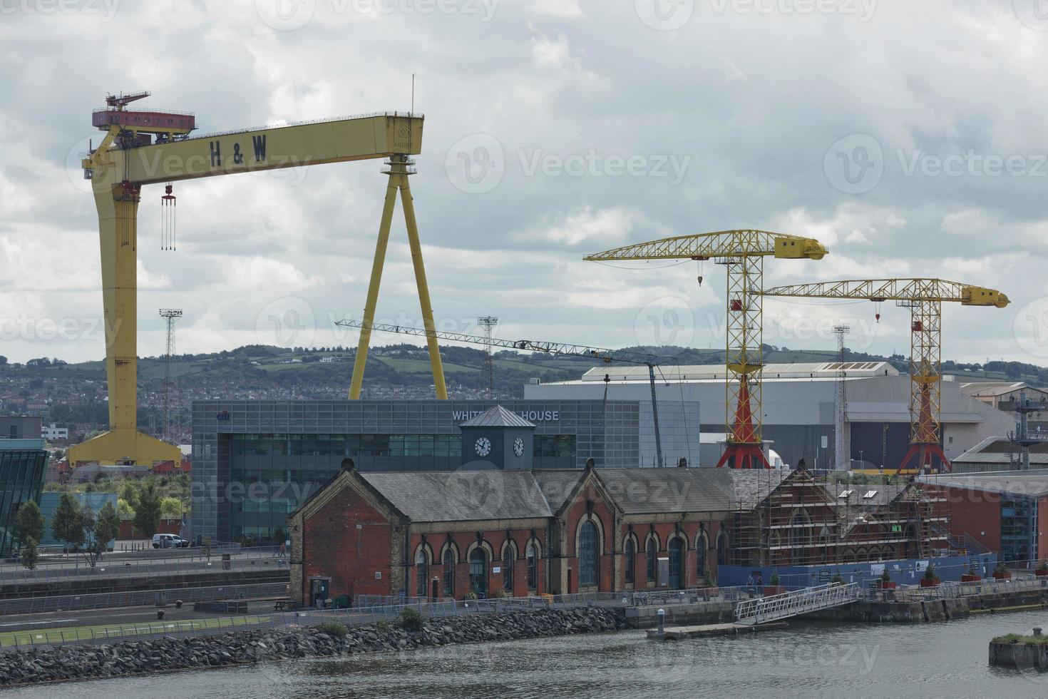 Grandi gru industriali che caricano la nave portacontainer nel porto di Belfast in Irlanda foto