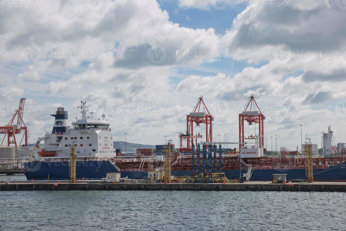 Grandi gru industriali che caricano la nave portacontainer nel porto di Dublino in Irlanda foto