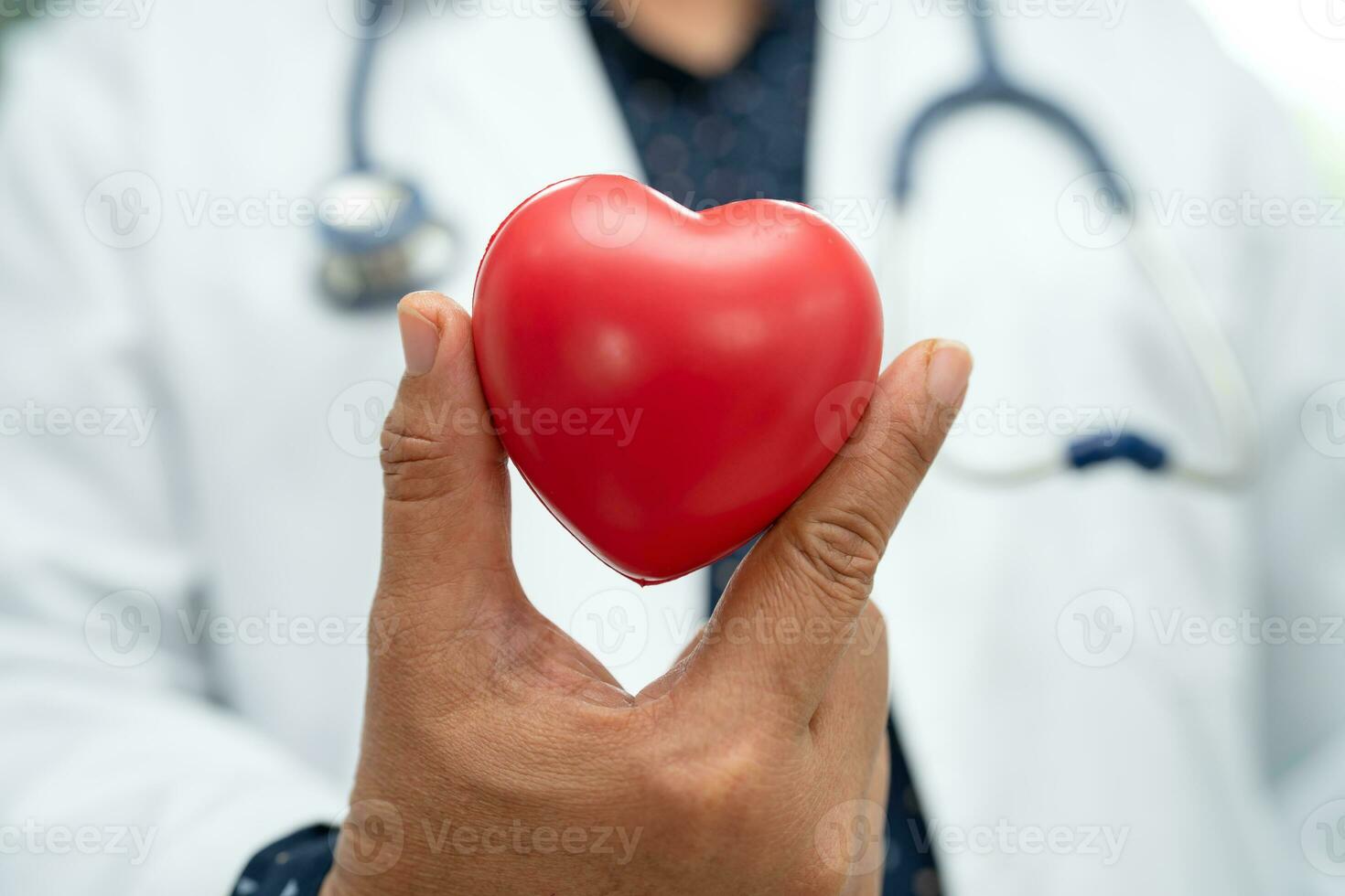 medico che tiene un cuore rosso nel reparto ospedaliero, concetto medico sano e forte. foto